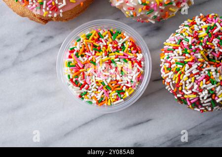 A top down view of a condiment cup of rainbow sprinkles. Stock Photo