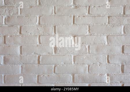 A view of a rustic masonry style brick wall painted white, as a background. Stock Photo