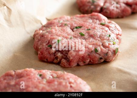 A closeup view of raw ground beef patties on butcher paper. Stock Photo