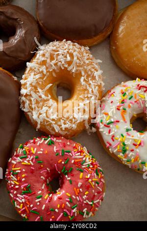 Top view of donuts in various colors and flavors on wooden table Stock ...
