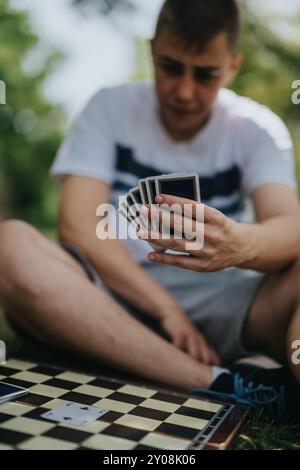 Young man strategizing card game move on sunny day Stock Photo