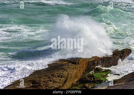 Storm Vs Rocks Wave crashing against rocks during storm Stock Photo - Alamy