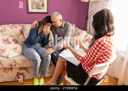 Female counselor, psychiatrist, talks with a teen girl and her father to solve problems. Parenting conflicts, kids crisis. Stock Photo