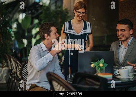 Business professionals enjoying a lively outdoor meeting in a cafe setting, sharing ideas while discussing work Stock Photo