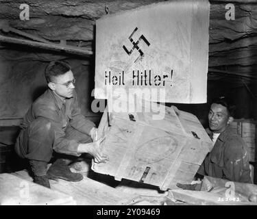 Two soldiers of the 90th Division, U.S. Third Army, remove a crate containing looted historical engravings that were discovered in the Merkers salt mine. Stock Photo