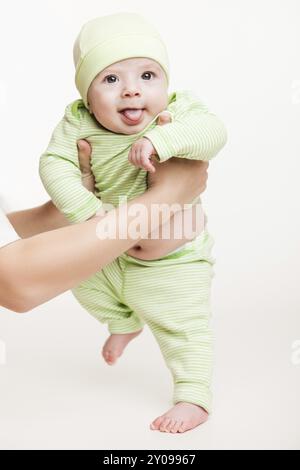 Walking toddler concept, little baby child boy making first step holding mother Stock Photo