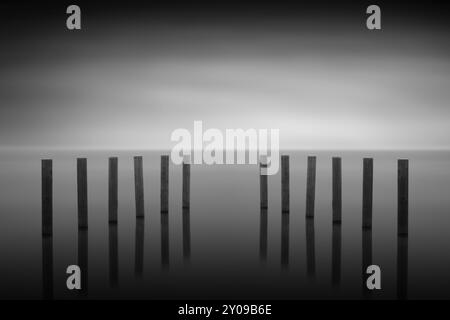 Wooden post in the lake, long exposure Stock Photo