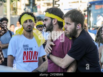 Jerusalem, Israel. 1st September 2024 A demonstrator hugging, trying to calm down another outrageous demonstrator in a demonstration in Jerusalem today, calling on the government to reach an urgent deal with Hamas, before more hostages are getting killed. The demonstrators wear a yellow ribbon on their forehead to signify this protest. A third demonstrator wearing a shirt with the slogan: 'Bring Them Home Now' is watching his two friends.  Credit: Yoram Biberman/Alamy Live News. Stock Photo
