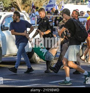 Jerusalem, Israel. 1st September 2024 Police officers arresting  Michal Deutsch a leading protestor in a demonstration in Jerusalem today. The demonstration called on the government to reach a deal with Hamas urgently before more hostages were killed. The policemen are carrying Michal in her limbs.  Credit: Yoram Biberman/Alamy Live News. Stock Photo