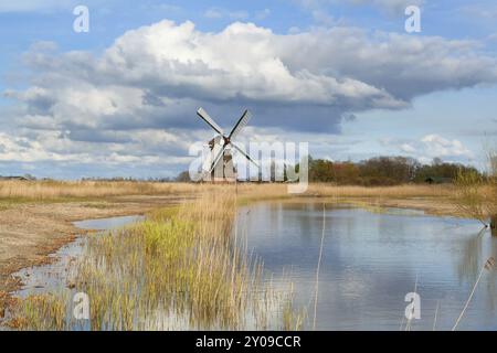 Dutch windmill over blue sky by river, Netherlands Stock Photo