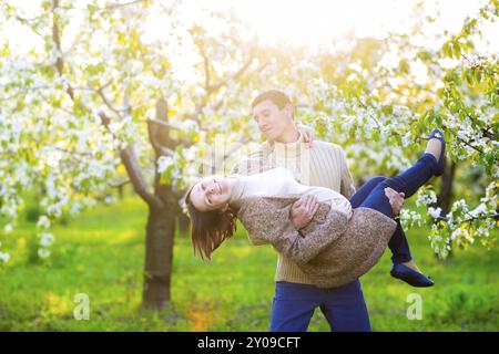 Portrait of a happy pregnant couple in the blossom garden Stock Photo