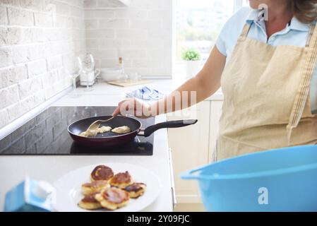 Woman cooking a pancakes at home. Close up Stock Photo
