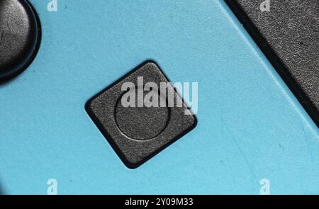 A black square button on a blue hand controller Stock Photo