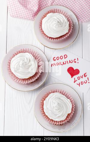 Cupcakes with white buttercream frosting on white wooden table Stock Photo