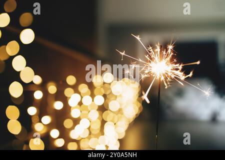 Sparklers on blurred christmas lights. Festive mood. Stock Photo