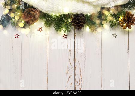 Christmas or new year background with scarf and pine cones and lights on white wooden table, flat lay over head view Stock Photo