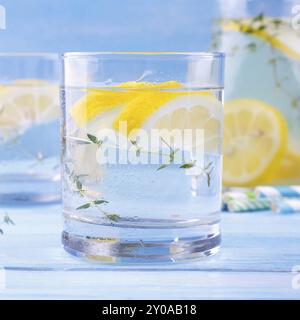 Closeup of beverage with lemon and thyme, on blue wooden background Stock Photo