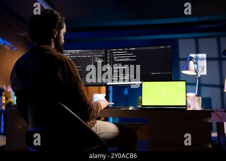 Developer working from home in apartment on green screen laptop, futureproofing company network from downtimes . Admin using chroma key notebook, increasing data security, close up Stock Photo