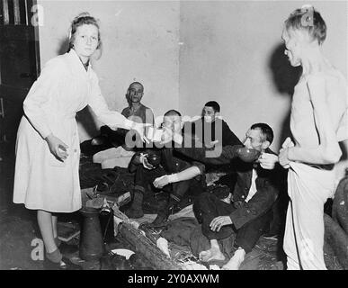 A German nurse hands out food to Russian, French, and Czech survivors from the Woebbelin concentration camp. The SS opened Wöbbelin in February 1945 to house concentration camp prisoners whom the SS had evacuated from other camps to prevent their liberation by the Allies. The camp was freed on May 2, 1945. Stock Photo