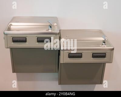Wall-mounted metal drinking fountains for taller and shorter people Stock Photo