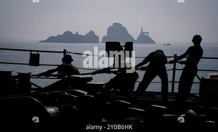 [240726-N-HV010-1059] Sailors and Marines heave around a mooring line on the forecastle of the amphibious dock landing ship USS Harpers Ferry (LSD 49) during exercise Ssang Yong as the ship makes port in Busan, South Korea, August 26, 2024. Exercise SY24 strengthens the Republic of Korea-U.S. Alliance through bilateral, joint training, contributing toward combined amphibious capability in defense of the Korean Peninsula. (U.S. Navy photo by Mass Communication Specialist 2nd Class Sang Kim) Stock Photo