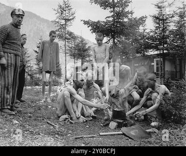 A group of emaciated survivors prepare a meal on an open fire in the newly liberated Ebensee concentration camp. Ebensee was a subcamp of Mauthausen concentration camp built by the SS in 1943 to build tunnels for armaments storage near the town of Ebensee, Austria. Though the Mauthausen complex was not an extermination centre abuse, cruelty and neglect were commonplace. Between 8,500 and 11,000 prisoners died in the camp, mostly from hunger or malnutrition. The US Army liberated the camp on 6 May 1945. Th photo is dated 8th May 1945, two days after liberation. Stock Photo