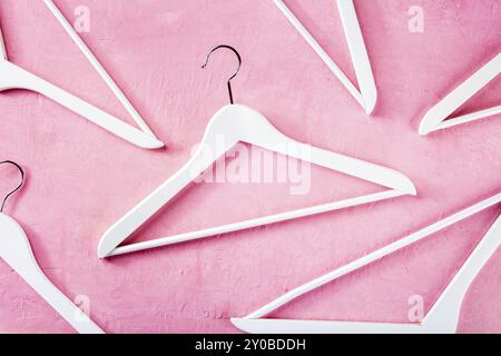 Fashion collection concept. White wooden hangers, a flat lay layout on pink. Shopping background, abstract design, Food photography Stock Photo