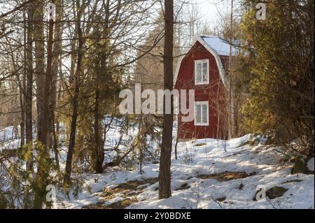 Red painted wooden house in a wintry landscape in the Swedish province of Smaland. Red painted wooden house in a wintry landscape in Sweden Stock Photo