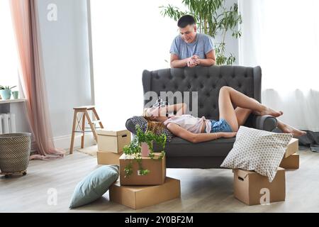 Young happy couple in room with moving boxes at new home Stock Photo