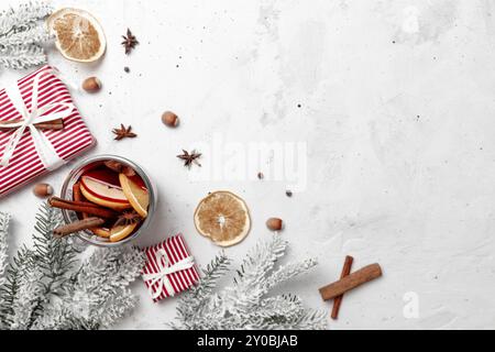Christmas flat lay top view on white gray concrete background table with Mulled Wine glass cup or mug, present red gift boxes, decorations, cinnamon, Stock Photo
