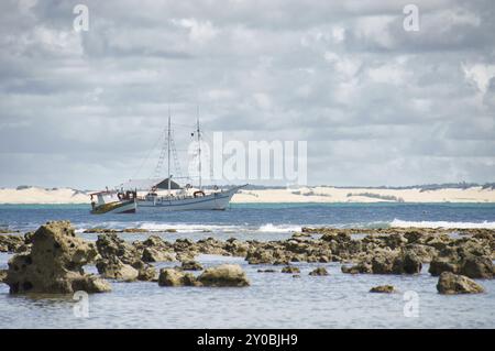 Beach at low tide with fishing boats and dunes in the background in Pipa, Brazil, South american, South America Stock Photo