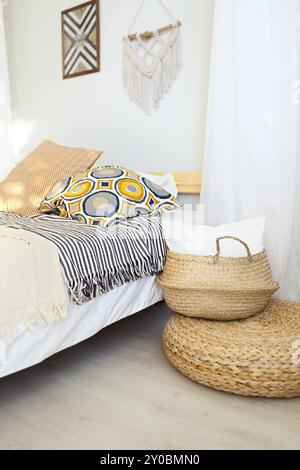 White and beige bedroom in boho style with macrame on the wall Stock Photo