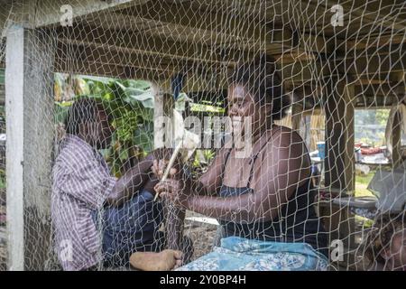 Chea Village, Solomon Islands, June 15, 2015: A woman is repairing a fishing net under her house in Chea Village, Oceania Stock Photo