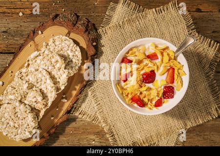 Continental breakfast with cornflakes, strawberries, rice crackers and a cup of milk seen from above Stock Photo