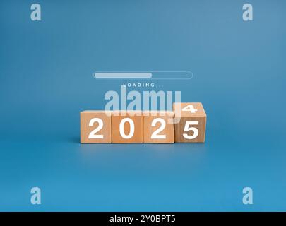 Coming to Merry christmas and happy new year 2025 banner background. Loading progress bar appears on wood flipping blocks with 2024 changes to 2025 ye Stock Photo