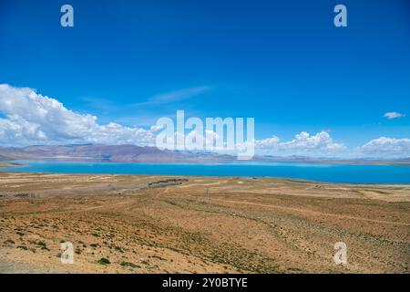 The sacred Manasarovar lake with blue transparent water in the mountains of Tibet under cloudy sky. Ngari scenery in West Tibet. Sacred place for Budd Stock Photo