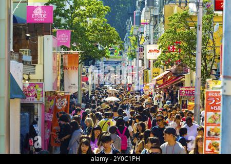 Tokyo, Japan, June 24, 2016: Many young people walking down crowded and bustling shopping street in consumerism mecca lined with stores on busy Takesh Stock Photo