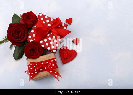 Valentine's, mother's day or birthday card with hearts, red roses and gift boxes on light blue background, flat lay with copy space Stock Photo