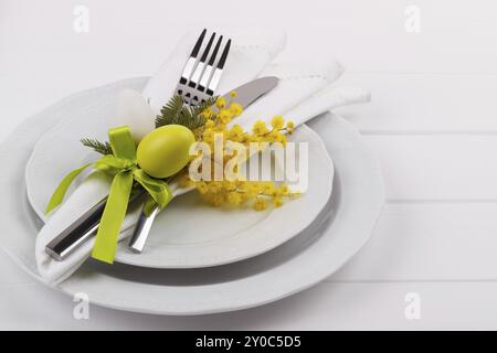 Easter dinner table setting on white wooden table, festive holiday background top view Stock Photo