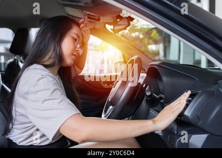 Hand checking the air conditioner in the car, The cooling system in the car. Girl driver being hot during heat wave in car, suffering from hot weather Stock Photo