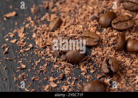Roasted coffee beans lie together with chocolate crumbled into small pieces, fragrant coffee together with chocolate crumbs Stock Photo