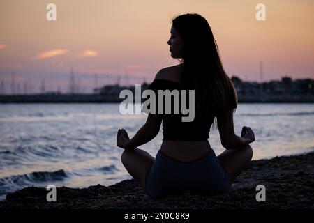 Young woman practising yoga, Sa Rapita beach, Campos, Mallorca, Balearic islands, Spain, Europe Stock Photo