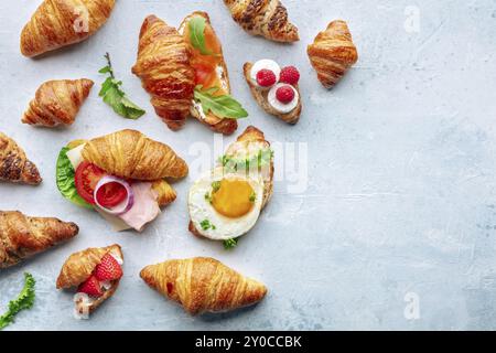 Croissant sandwich assortment. Various stuffed croissants, overhead flat lay shot. Rolls filled with ham, salmon, egg, etc, with copy space Stock Photo