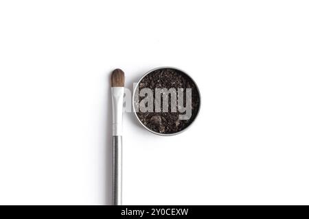 Dark brown face shadow in container and eye shadow or make-up brush. Makeup concept flat lay on white background Stock Photo