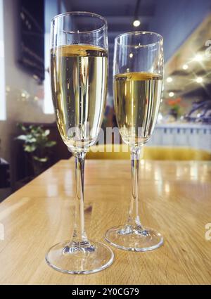 Two champagne glasses on wooden table at restaurant Stock Photo