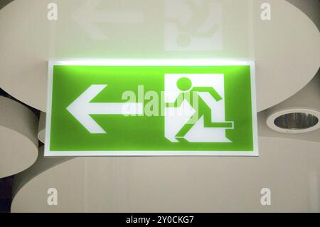 Green emergency exit sign in a station Stock Photo