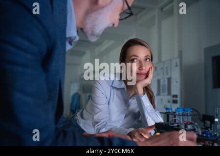 Two robotics engineers working on new project, standing in laboratory. Concept of modern technology in industries, automated processes, automotive Stock Photo