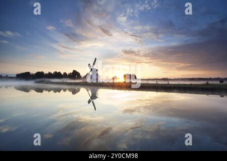 Sunrise over Dutch windmill and river, Holland Stock Photo