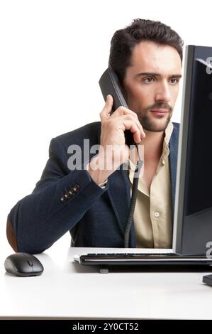 Man looking at a computer screen, on the phone, thinking about the job at hand Stock Photo