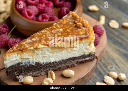 Cheesecake with chocolate sponge cake and peanuts in caramel, delicious dessert with peanuts and cheese cream Stock Photo